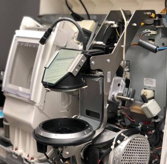 Detalhe interno de equipamento óptico em manutenção Eletroptica